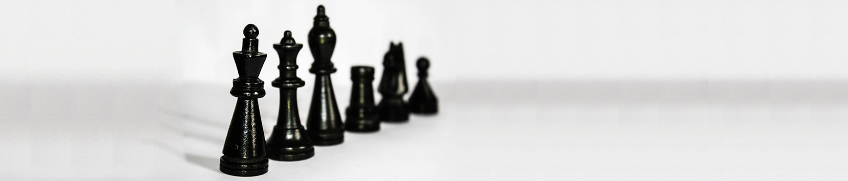 Zwarte schaakstukken op een witte achtergrond als symbool voor strategie